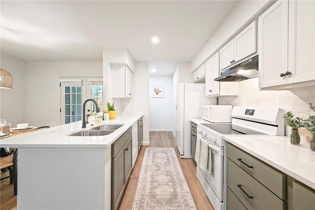 2800 Longmire Dr Unit 22, College Station, TX 77845 - kitchen with white appliances, under cabinet range hood, a sink, a peninsula, and light wood-type flooring
