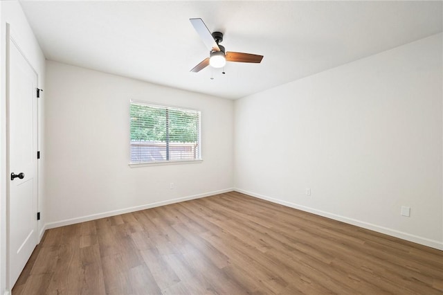 2800 Longmire Dr Unit 22, College Station, TX 77845 - empty room with wood finished floors, a ceiling fan, and baseboards