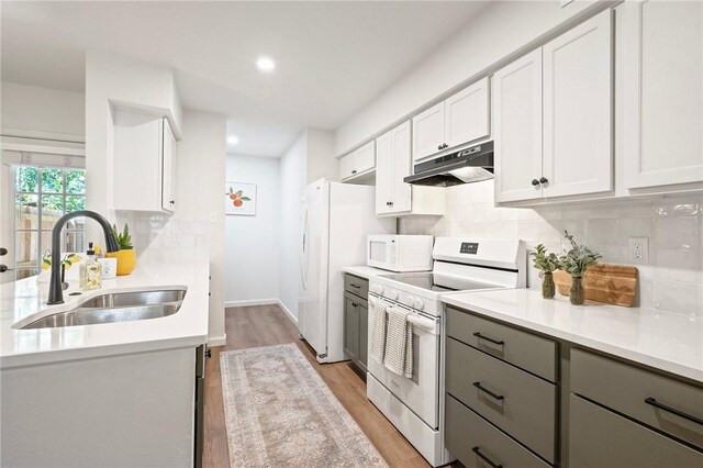 2800 Longmire Dr Unit 22, College Station, TX 77845 - kitchen featuring white appliances, under cabinet range hood, a sink, gray cabinets, and tasteful backsplash
