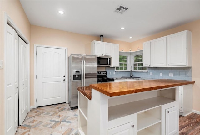 kitchen featuring open shelves, stainless steel appliances, wooden counters, a sink, and visible vents