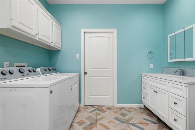 laundry area with washing machine and clothes dryer, a sink, cabinet space, and baseboards