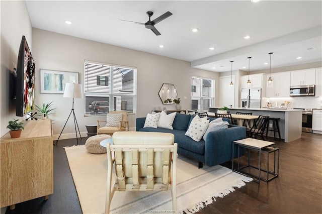 living area with a ceiling fan, wood finished floors, and a wealth of natural light