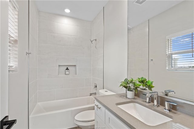 bathroom with shower / bath combination, vanity, toilet, and visible vents