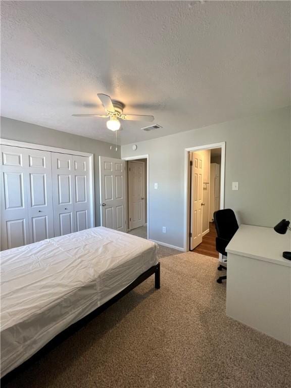 bedroom with a textured ceiling, carpet floors, ceiling fan, and a closet