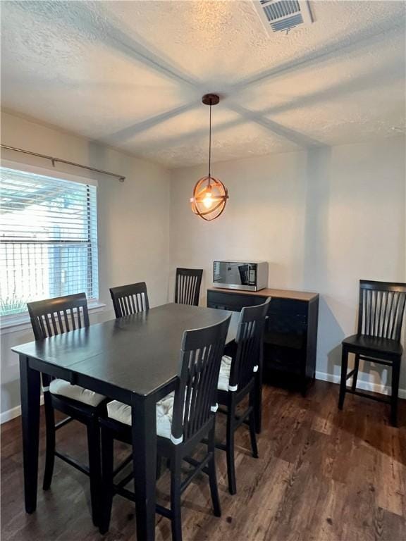 dining space featuring a textured ceiling and dark hardwood / wood-style floors