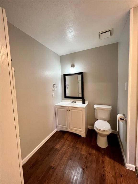 bathroom featuring toilet, vanity, and hardwood / wood-style floors