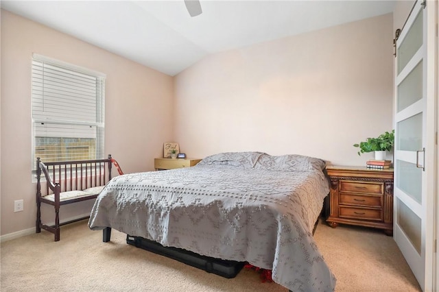 carpeted bedroom with a barn door, ceiling fan, and lofted ceiling