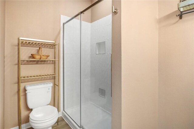 bathroom with walk in shower, hardwood / wood-style flooring, and toilet