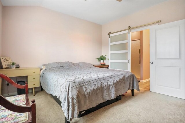 carpeted bedroom featuring a barn door