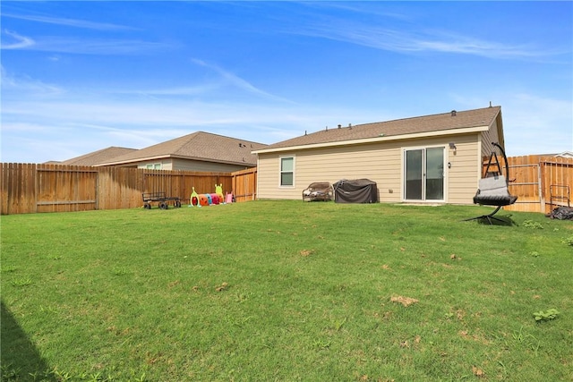 rear view of house featuring a yard