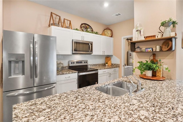 kitchen featuring white cabinetry, light stone countertops, and appliances with stainless steel finishes