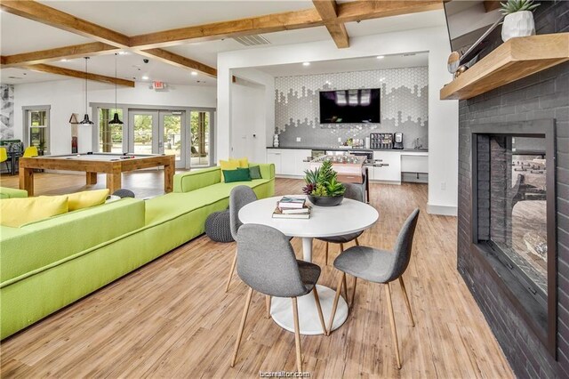 dining area featuring french doors, light hardwood / wood-style flooring, beamed ceiling, bar, and pool table