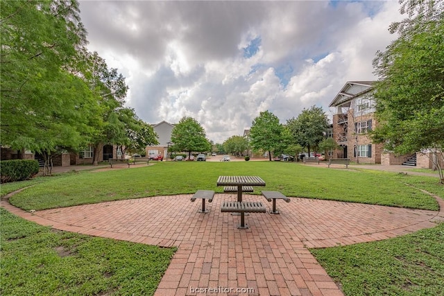 view of property's community featuring a patio area and a lawn