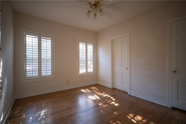 unfurnished bedroom with ceiling fan, dark hardwood / wood-style flooring, and multiple windows