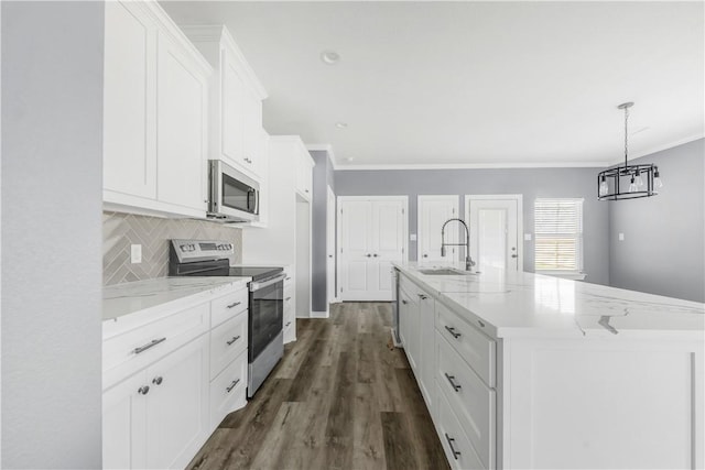611 Levy St, Navasota, TX 77868 - kitchen featuring stainless steel appliances, a sink, ornamental molding, white cabinets, and backsplash