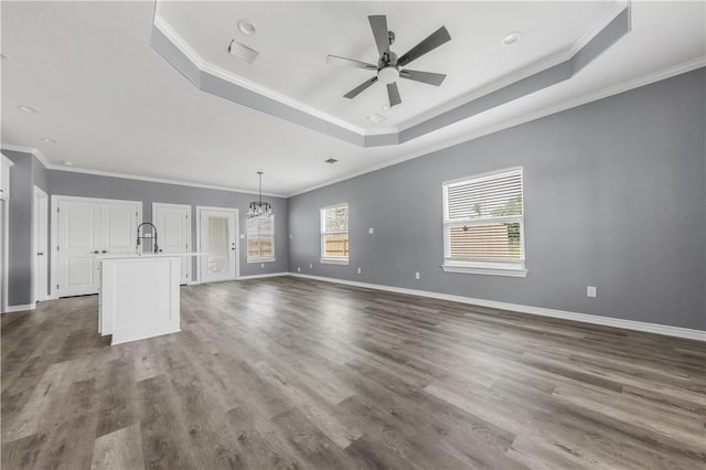 611 Levy St, Navasota, TX 77868 - unfurnished living room featuring a tray ceiling, plenty of natural light, a ceiling fan, crown molding, and baseboards