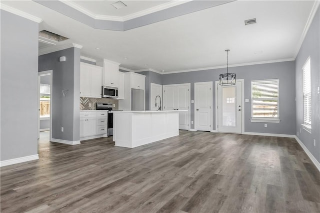 611 Levy St, Navasota, TX 77868 - kitchen with stainless steel appliances, white cabinetry, wood finished floors, a sink, and crown molding