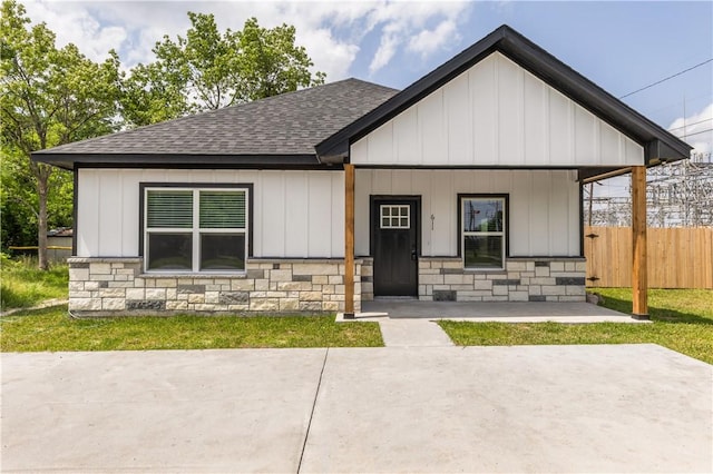 611 Levy St, Navasota, TX 77868 - view of front of house featuring a shingled roof, fence, stone siding, and board and batten siding