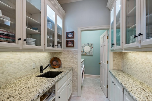 kitchen featuring white cabinetry, tasteful backsplash, sink, and light stone counters