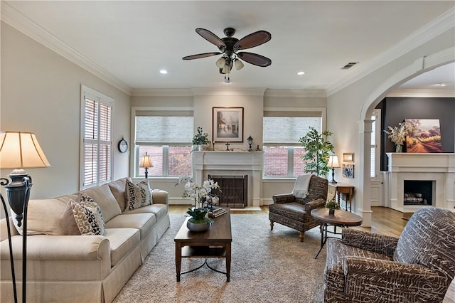 living room featuring crown molding, ceiling fan, and light wood-type flooring