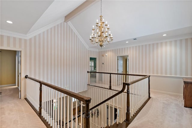 hall with an inviting chandelier, ornamental molding, lofted ceiling, and carpet