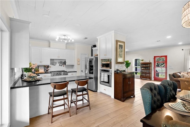 kitchen featuring a peninsula, dark countertops, appliances with stainless steel finishes, and open floor plan