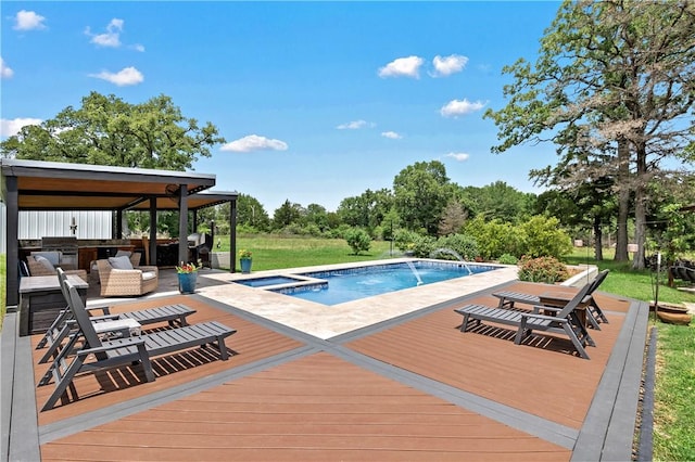 outdoor pool featuring a grill, a deck, an in ground hot tub, and area for grilling