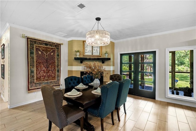 dining area featuring visible vents, an inviting chandelier, crown molding, baseboards, and light wood-style floors