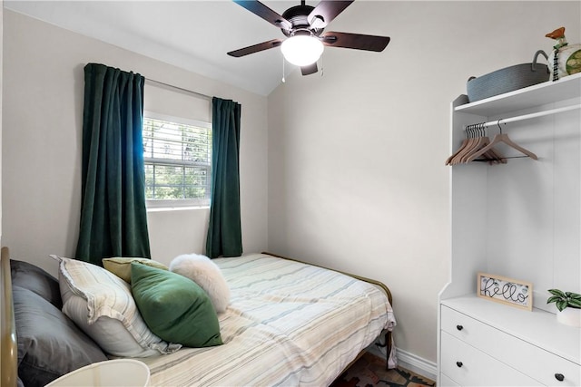 bedroom with a ceiling fan, baseboards, and lofted ceiling