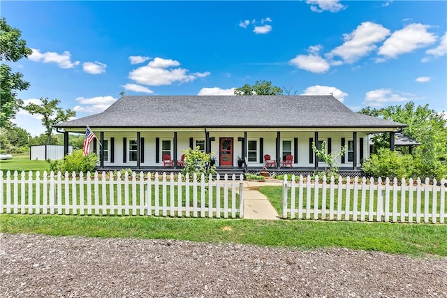 view of front of home with a front yard, a fenced front yard, and covered porch