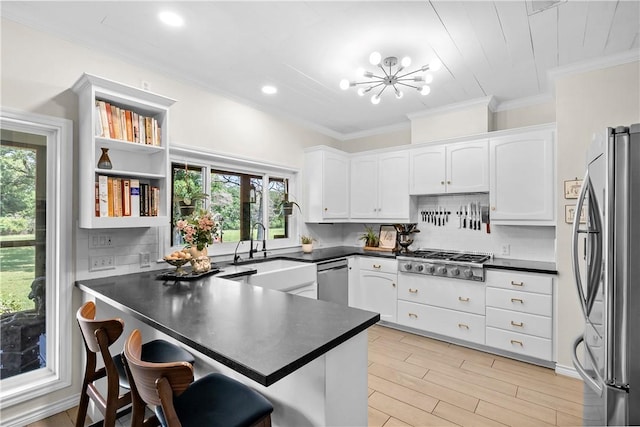 kitchen with a peninsula, stainless steel appliances, crown molding, and plenty of natural light