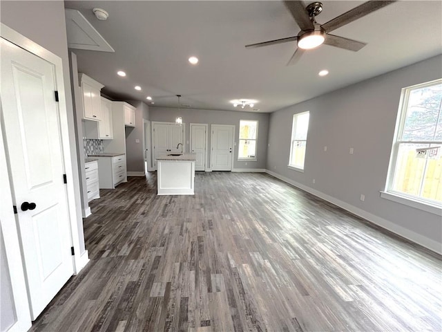 kitchen with open floor plan, baseboards, white cabinets, and a healthy amount of sunlight