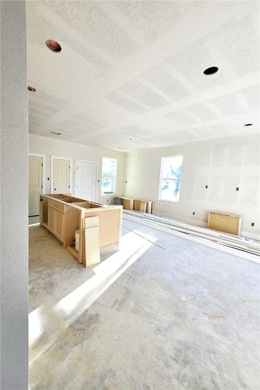 kitchen with light brown cabinetry, a kitchen island, and a textured ceiling