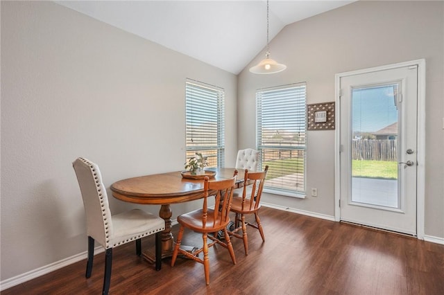 dining space featuring vaulted ceiling, wood finished floors, and baseboards