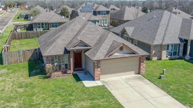 craftsman house featuring a front lawn, fence, a residential view, concrete driveway, and an attached garage