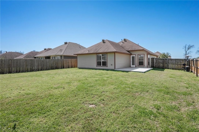 rear view of property featuring a patio area, a lawn, and a fenced backyard