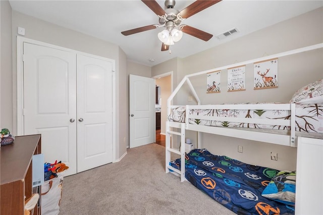 carpeted bedroom featuring visible vents, a closet, and ceiling fan