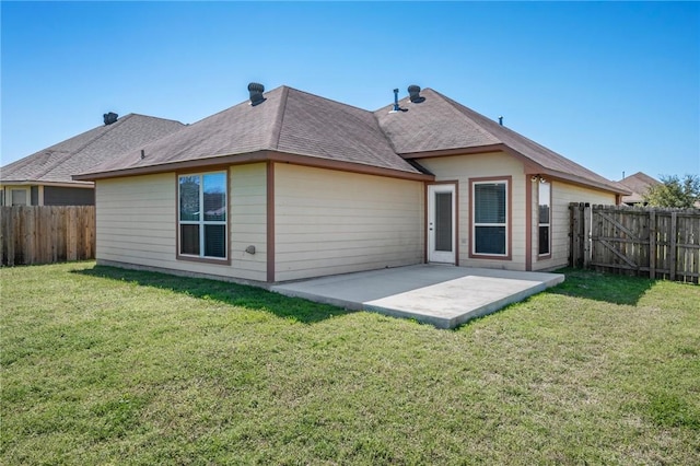 rear view of house featuring a fenced backyard, a lawn, and a patio