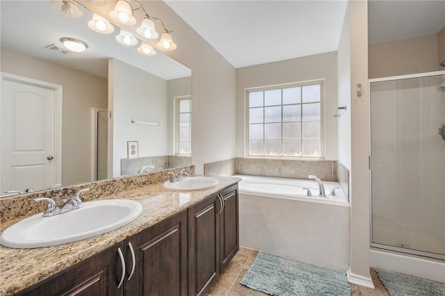 bathroom featuring a sink, a garden tub, and a stall shower