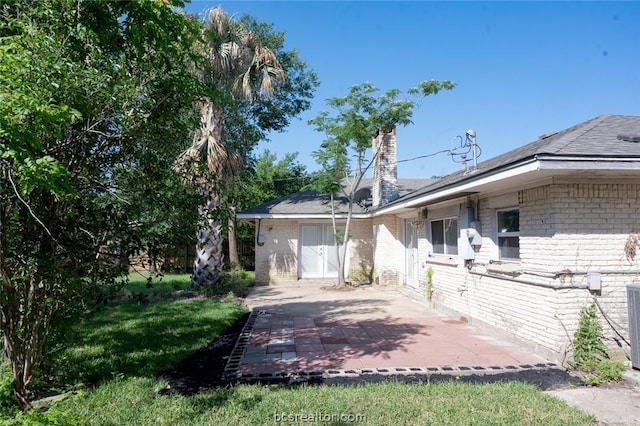 view of property exterior featuring a lawn and a patio