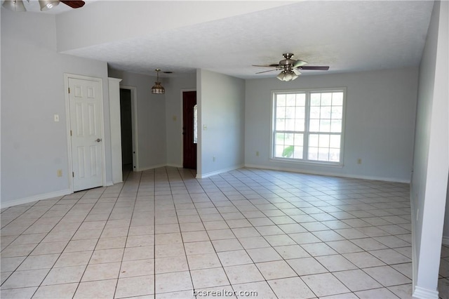 tiled empty room featuring a textured ceiling and ceiling fan