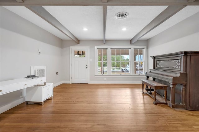 misc room with beam ceiling and light wood-type flooring