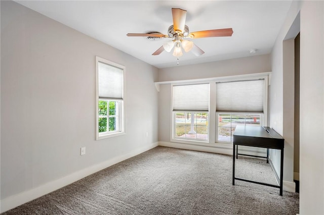 empty room featuring ceiling fan, carpet, and a healthy amount of sunlight