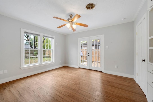 empty room with french doors, ceiling fan, and wood-type flooring