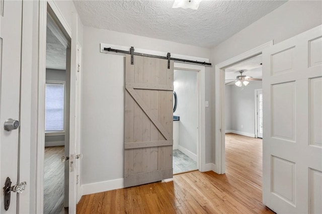 interior space with wood-type flooring, a barn door, and a textured ceiling