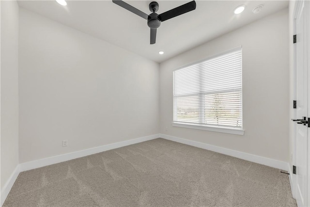 spare room featuring light colored carpet and ceiling fan