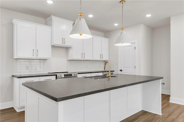 kitchen with an island with sink, pendant lighting, and white cabinets