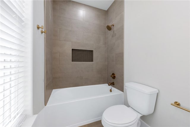 bathroom with tiled shower / bath and toilet