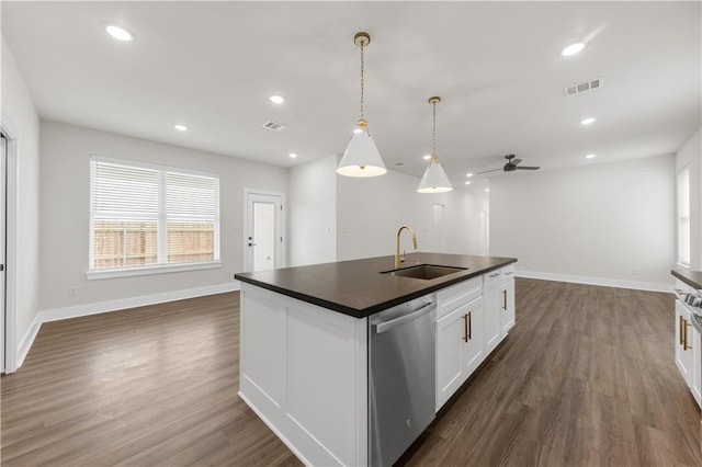 kitchen with sink, white cabinetry, decorative light fixtures, stainless steel dishwasher, and an island with sink