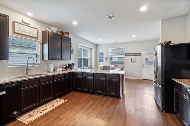 974 Marquis Dr, Bryan, TX 77803 - kitchen featuring black dishwasher, freestanding refrigerator, wood finished floors, dark brown cabinets, and a peninsula